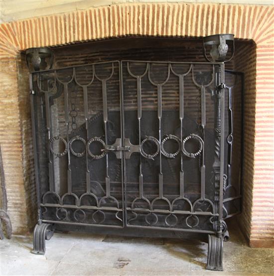 A large wrought iron scrollwork and wire mesh chimney piece spark guard, approx. W.4ft 10.5in. x 3ft 11.75in.